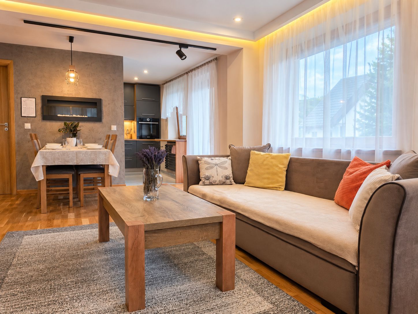 Sofa i stolik w salonie, z jadalnią i otwartą kuchnią w tle